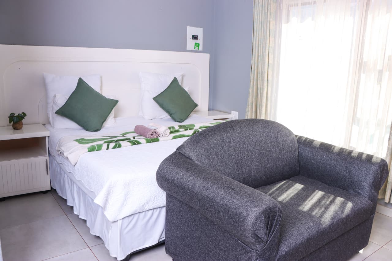 Room with a double bed and armchair at The Elephant Lodge